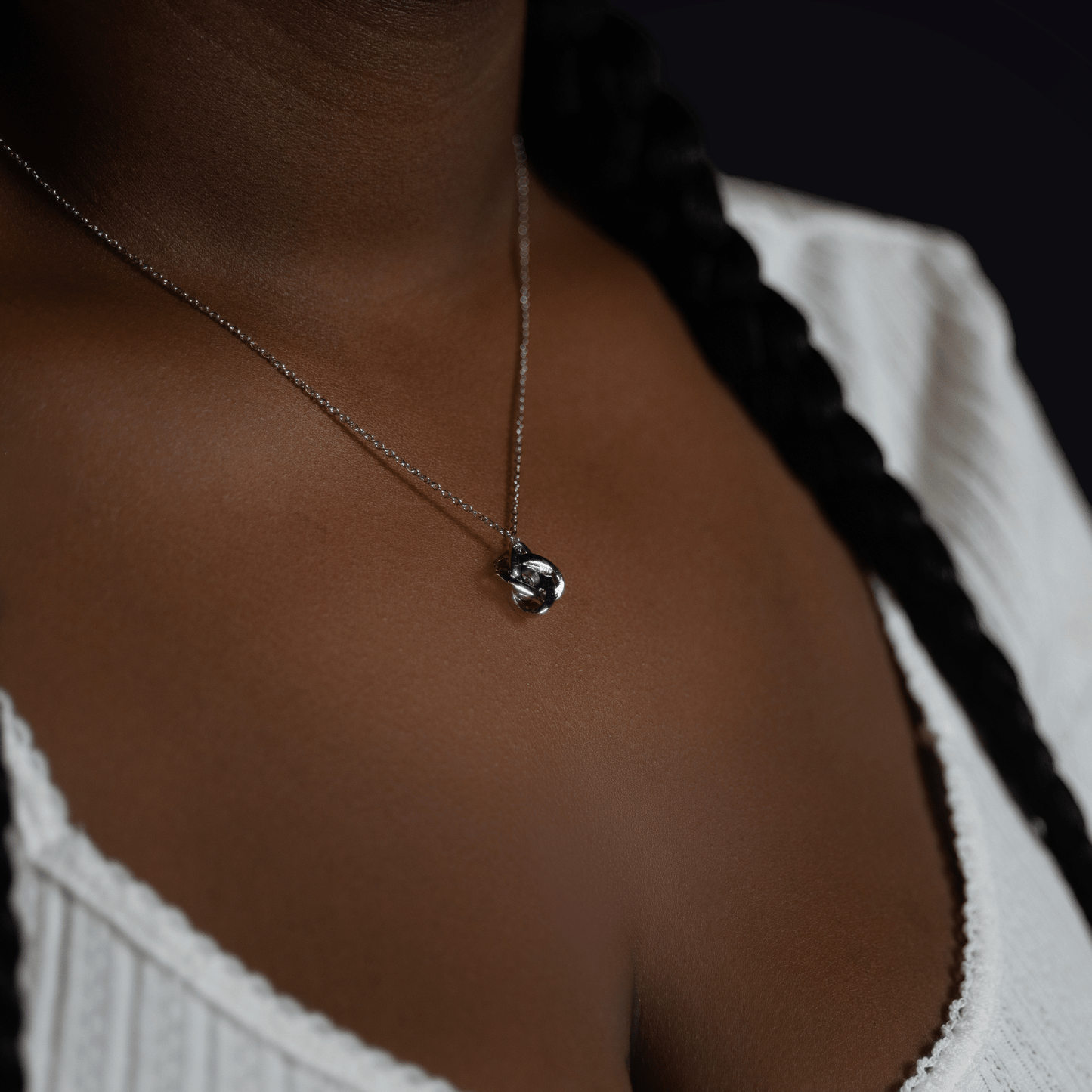 Silver interlocking hearts pendant necklace on model