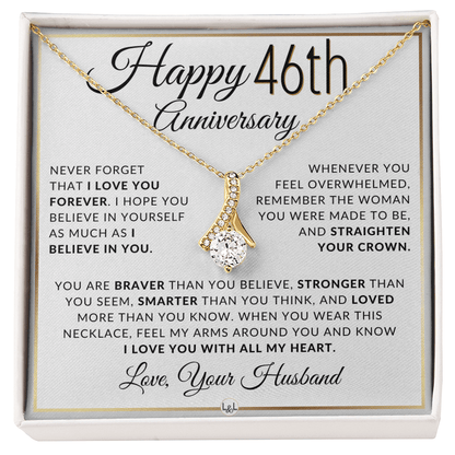 Gold 46th birthday necklace with a rhinestone pendant, presented on a square white gift card with anniversary messages and the text 'Love, Your Husband'.