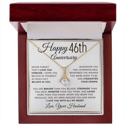 Gold 46th birthday necklace with a rhinestone pendant, presented on a square white gift card with anniversary messages and the text 'Love, Your Husband'.