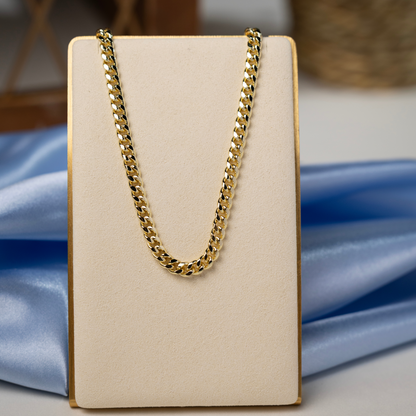 Gold Cuban link chain necklace displayed on a jewelry stand, highlighting its polished finish and classic curb link design.
