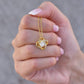 Woman holding gold cubic zirconia pendant necklace on delicate chain