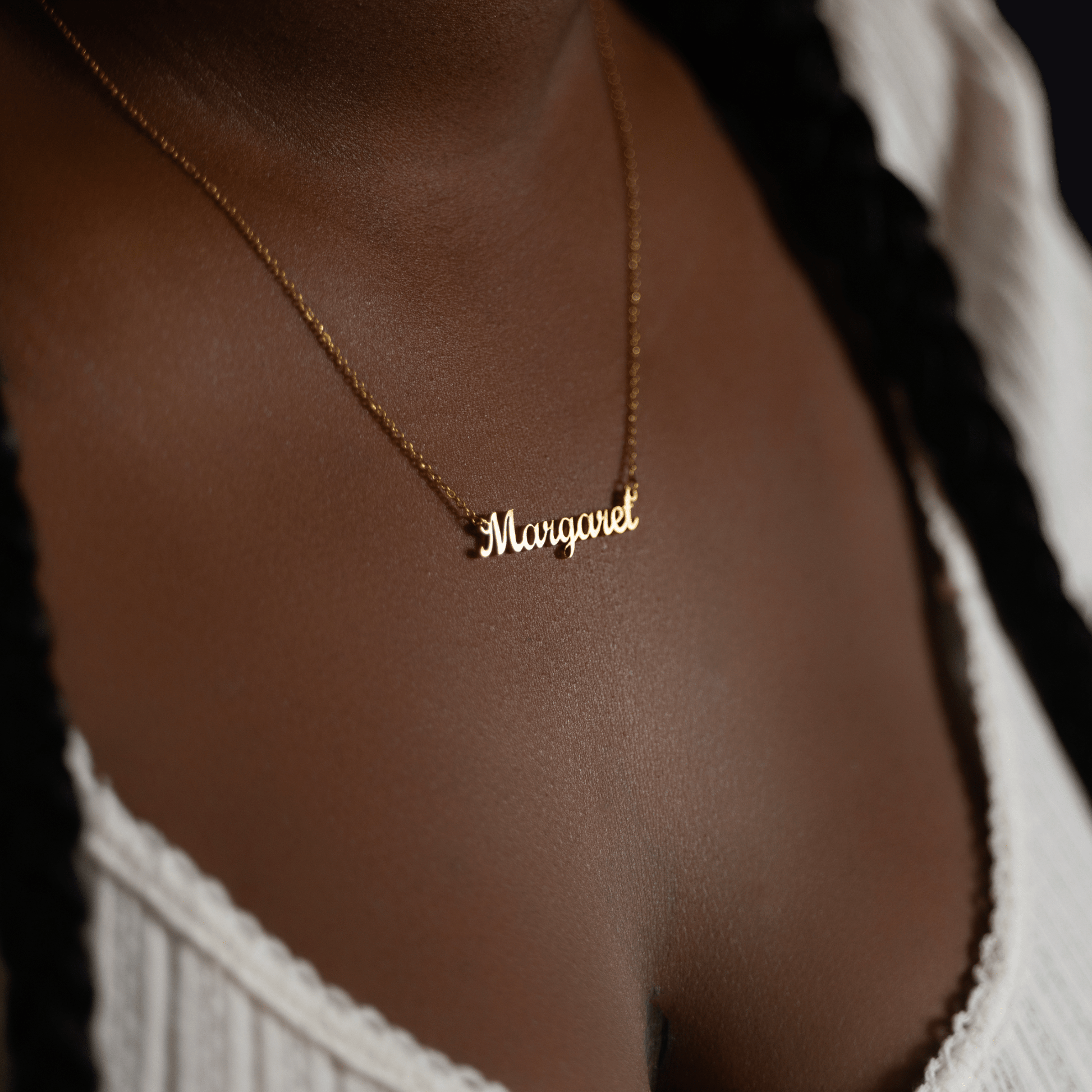 Woman wearing a custom gold name necklace engraved with the name Margaret