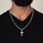Men’s silver cross pendant necklace on a Cuban link chain worn with a black shirt
