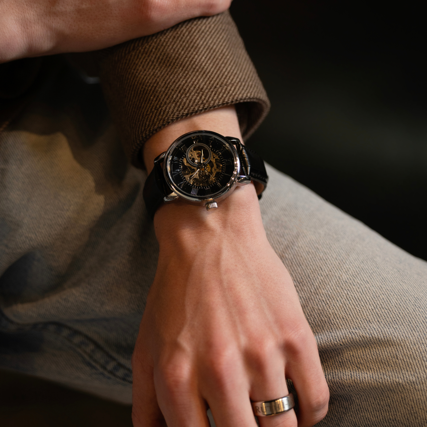Close-up of a luxury black skeleton watch with leather band