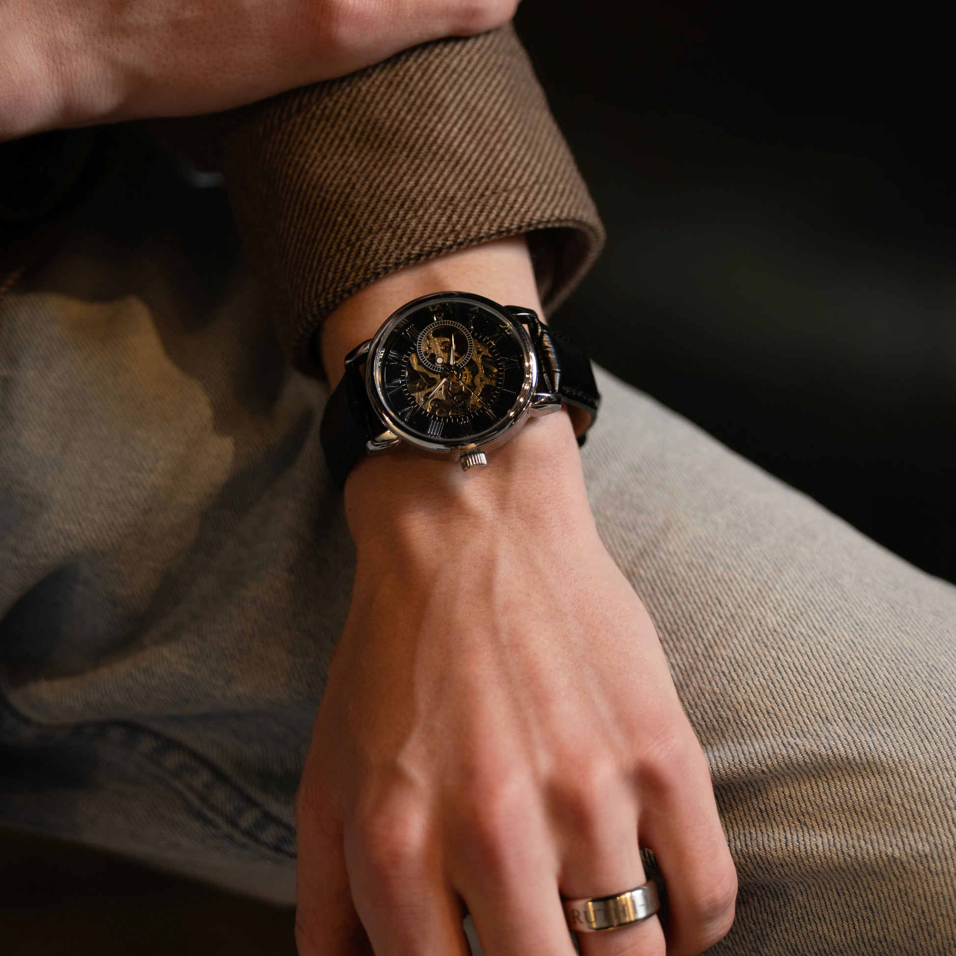 Close-up of a luxury black skeleton watch with leather band