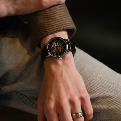 Close-up of a luxury black skeleton watch with leather band