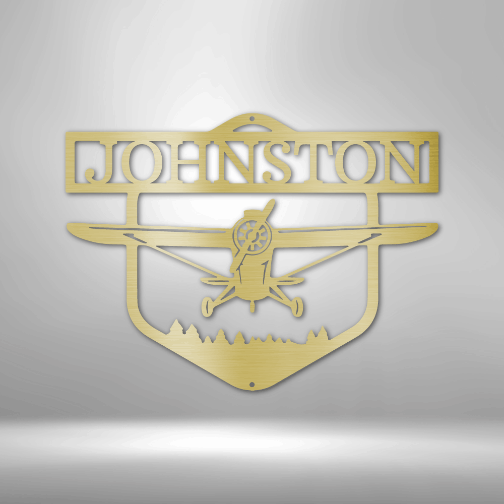 Decorative metal sign with airplane silhouette and 'Johnston' text on a white brick wall background