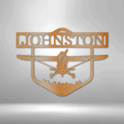 Decorative metal sign with airplane silhouette and 'Johnston' text on a white brick wall background