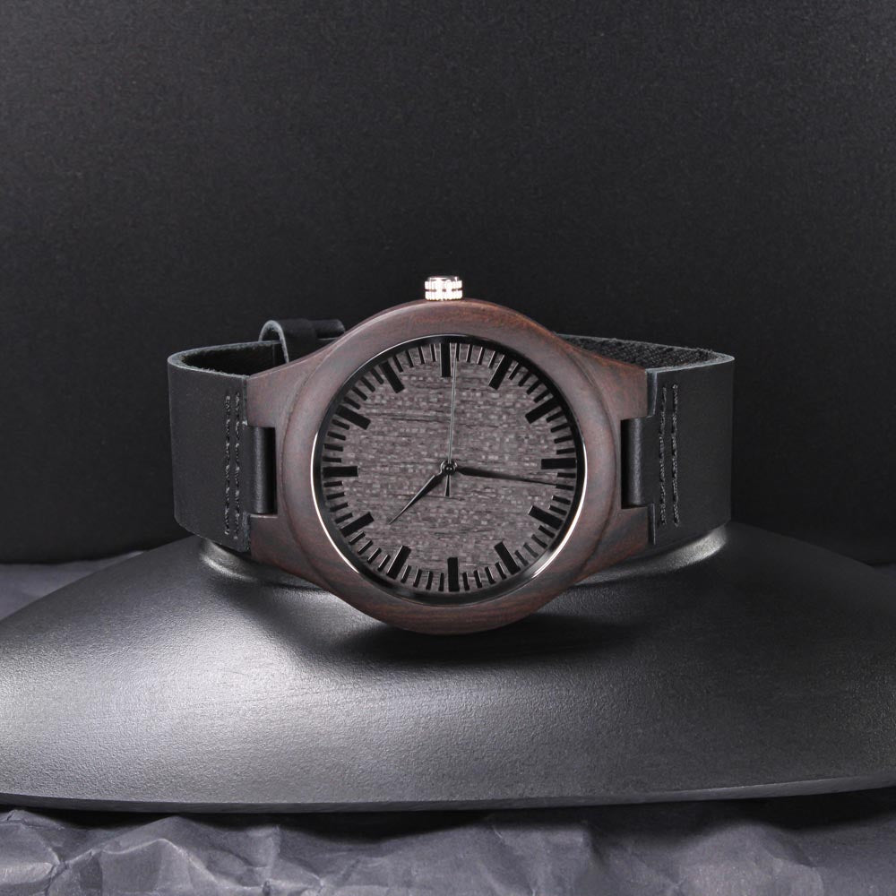 Dark wood men’s watch with black leather strap on a black background